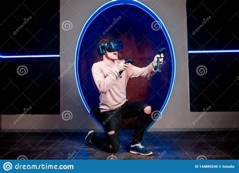 A Young Guy Plays Video Games In A Game Room In A Virtual Reality