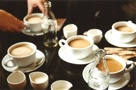 There Are Many Cups And Saucers On The Table With Some Drinks In Front