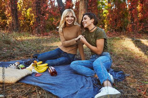 A Beautiful Couple Of Lesbian Ladies Having A Picnic In The Park The Young Women Sitting On