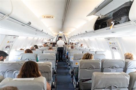 Interior Of Commercial Airplane With Passengers On Their Seats During