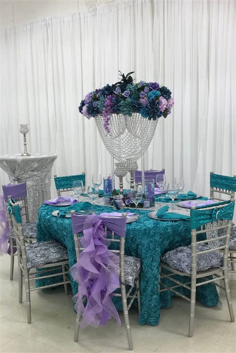 the table is set with purple and blue decorations