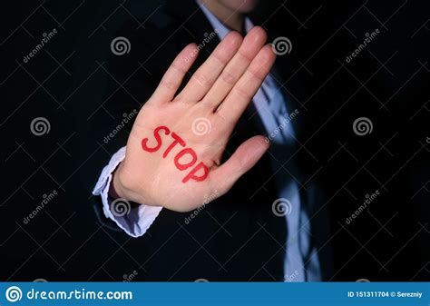 Woman With Word Stop Written On Her Palm Against Black