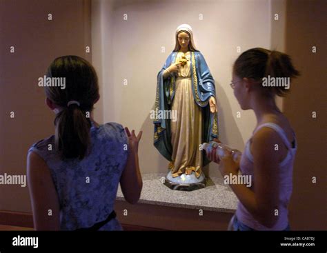 Two Girls Look At A Virgin Mary Statue During A Tour Of The Newly Built
