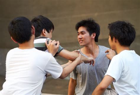 Teen Rivalry Asian Teen Shoving His Friend While Another Tries To