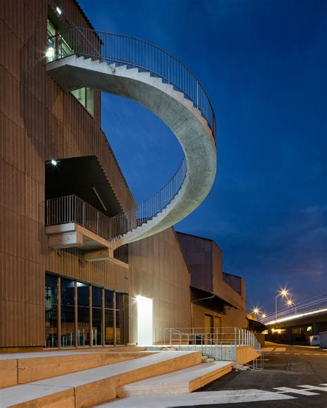 A Curving Concrete Staircase Protrudes From Warehouse Like Circus