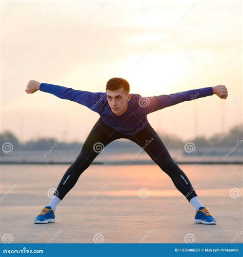 Young Male Runner Stretching before Run at Sunset. Healthy Lifestyle