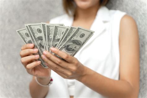 Close Up Mulher Segurando Dinheiro Notas De Dólar Na Mão Foto Grátis