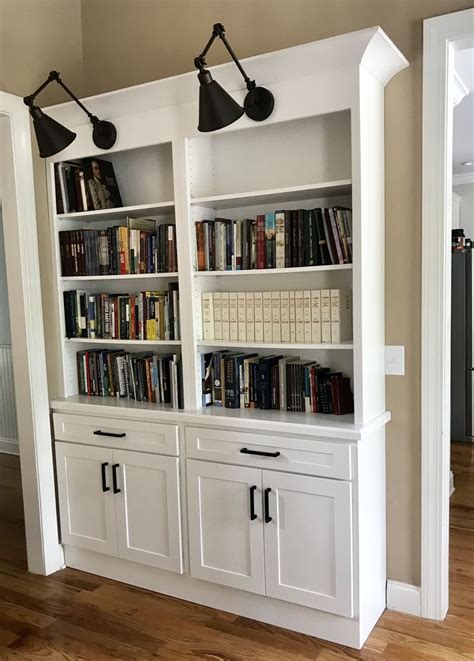To find out more about our antique white it works equally well with blacks, deep blues, or other dark colors. Built-in bookshelf with white shaker cabinets and black hardware and wall lamps. | White shaker ...