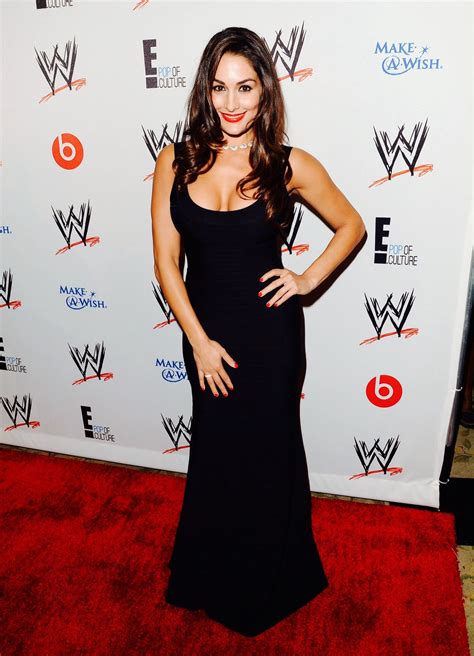 A Woman In A Black Dress Standing On A Red Carpet With Her Hands On Her