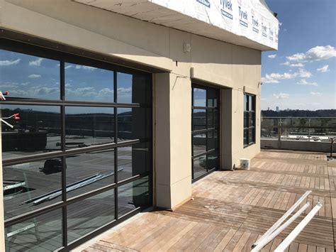 Full View Glass Garage Doors Installed On A Roof Top In Atlanta Low E
