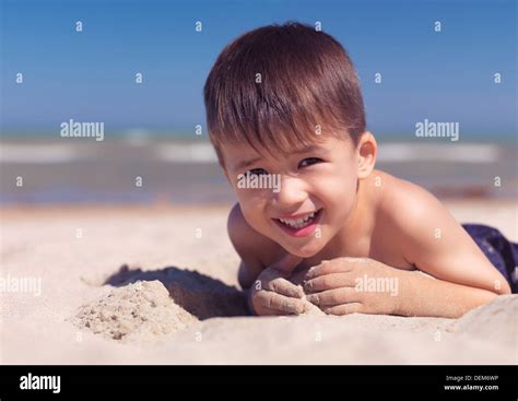 Portrait Of A Cute Heureux Enfant Jouant Dans Le Sable Sur La Plage Le