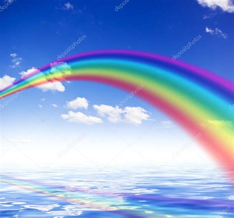 Blue Sky Background With Rainbow And Reflection In Water