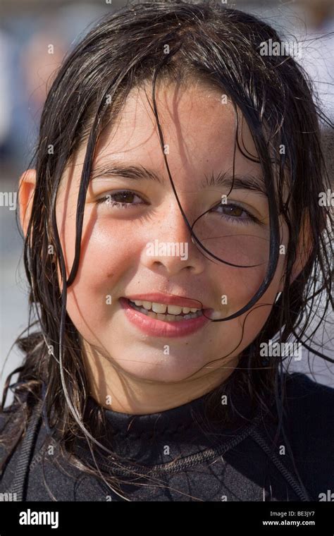 Portrait Of A Happy 10 Year Old Girl Wearing A Wet Suit While On A Body