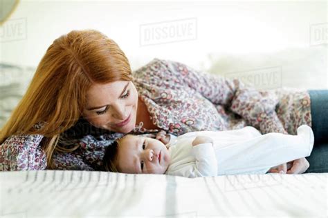 Mother Lying On Bed With Her Newborn Son Stock Photo Dissolve