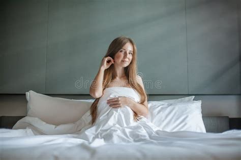 Woman With Beautiful Long Hair Sitting And Relax On The Bed With White