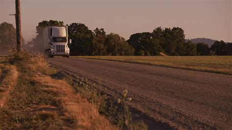 Semi Truck Driving Down Dusty Road At Sunset Fully Released For