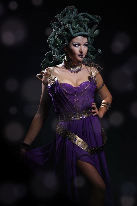 A Woman In A Purple Dress With Snakes On Her Head And Hands Behind Her Back