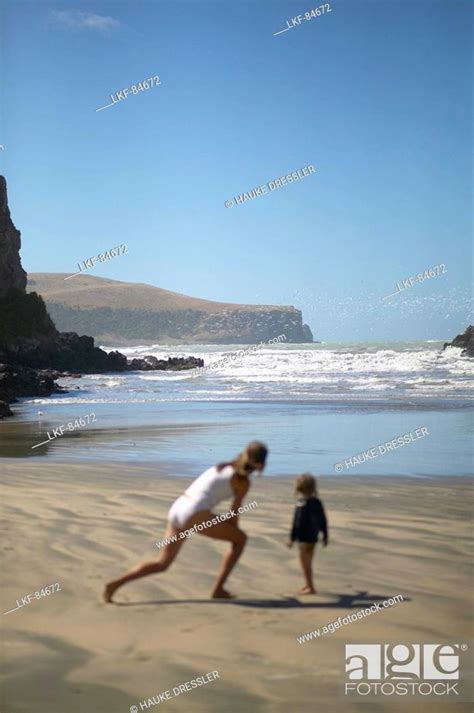 Mother And Child Playing At The Beach Of Little Okains Bay At Low Tide