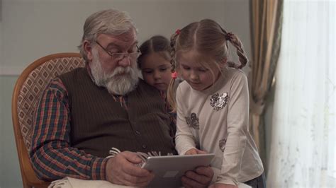 Grandfather Shows His Two Cute Granddaughters Something On The Tablet