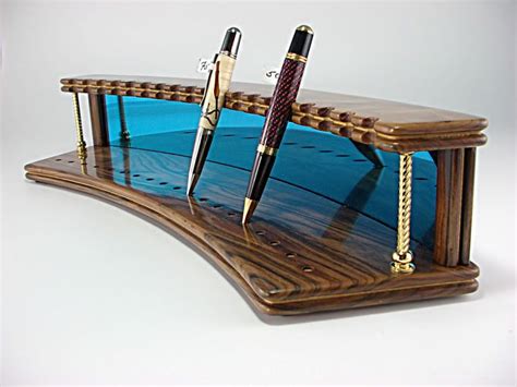 A Wooden Desk With Two Pen Holders On Top Of It And One Holding Three Pens