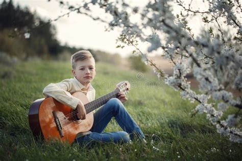 Cute Boy Making Music Playing The Guitar On Nature Stock Photo Image