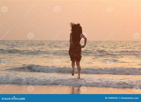 girl runs along the beach at sunset stock image image of ocean wave 70304347