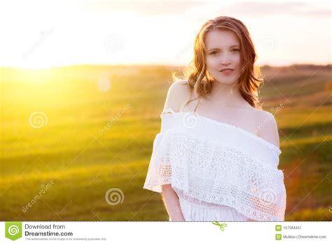 Cute Young Blonde Woman In In Green Field At Summer Or Spring Sunset