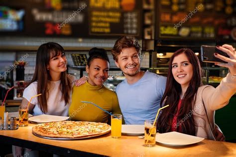 Multiracial Friends Having Fun Eating Pizza In Pizzeria Stock Photo By