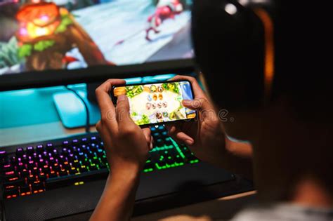 Teenage Gamer Boy Playing Video Games On Smartphone And Computer Stock
