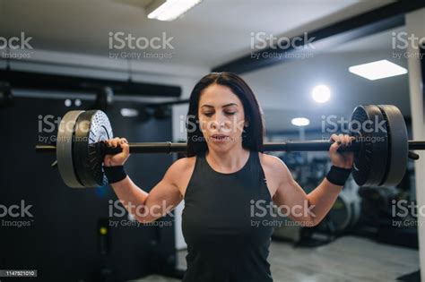 Gorgeous Black Haired Mature Fitness Coach Doing Weighted Squats At Her