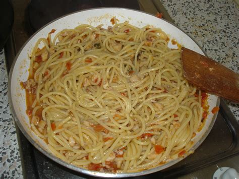 Lavare i calamari ed i totani, metterli in una padella con un filo di olio e saltarli a fuoco medio per qualche minuto. Spaghetti con cozze, calamari, totani e pomodori