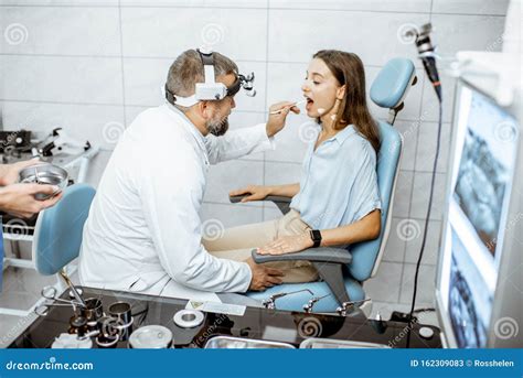 Otolaryngologists Examining Young Patient In Ent Office Stock Image