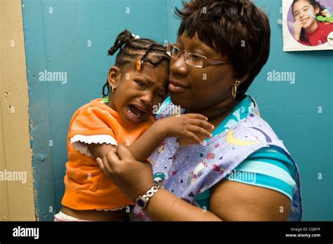Nursery School Teacher Comforts Upset Child Stock Photo Alamy
