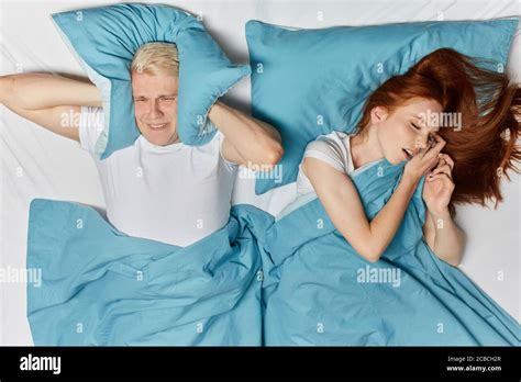 Ginger Woman Snoring In Sleep And Blonde Man Suffering On A Bed Top