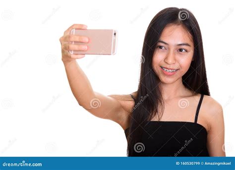 Adolescente Asi Tico Feliz Joven Que Sonr E Mientras Que Toma El Selfie Con Imagen De Archivo