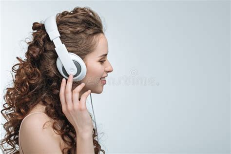 Side View Of Attractive Young Woman Listening Music In Headphones Stock
