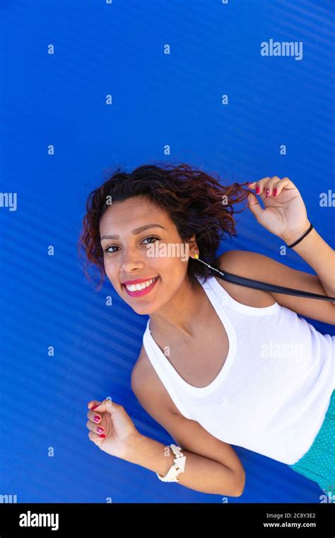 Portrait Of Latin American Brunette Woman Posing Smiling And Happy Blue Background Space For