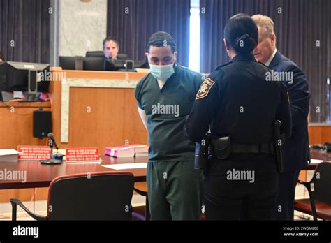 Cesar Santana in court wearing a jailhouse uniform and handcuffs. Cesar