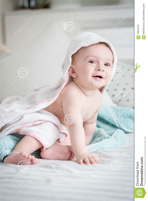 Smiling 9 Months Old Baby Boy Sitting On Bed Covered In Towel Af Stock