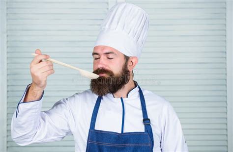 Man With Beard In Cook Hat And Apron Hold Cooking Tools Cooking As Professional Occupation