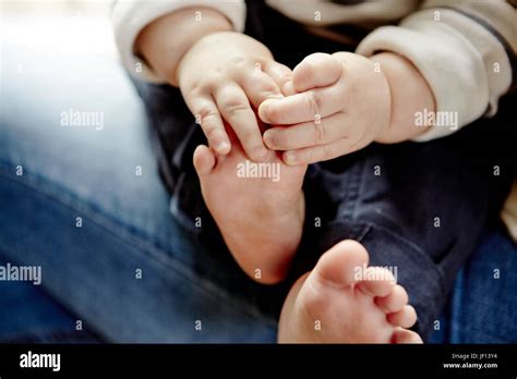 Babys Hands Holding Feet Stock Photo Alamy