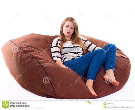 Girl Sitting On A Braun Beanbag Chair Royalty Free Stock Photo