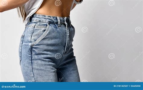 Woman Showing Her Slim Waist Closeup Girl In A White Top And Blue Jeans Demonstrates Her