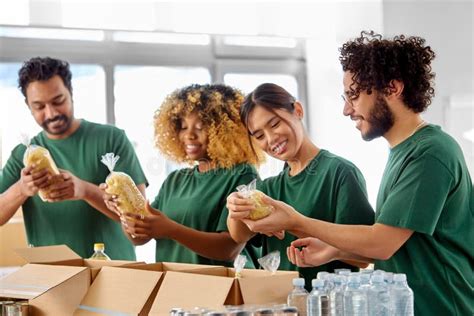 Happy Volunteers Packing Food In Donation Boxes Stock Photo Image Of