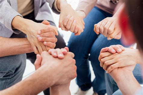 Cropped View Of People Holding Hands During Group Therapy Session Stock