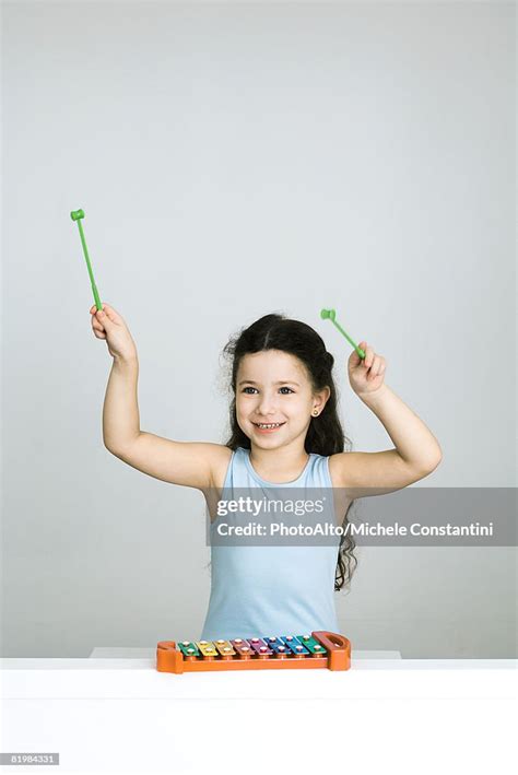 Little Girl Playing Xylophone Arms Raised Smiling High Res Stock Photo