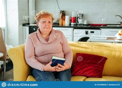 толстая старая женщина с книгой в руке смотрящая в камеру Стоковое Изображение изображение