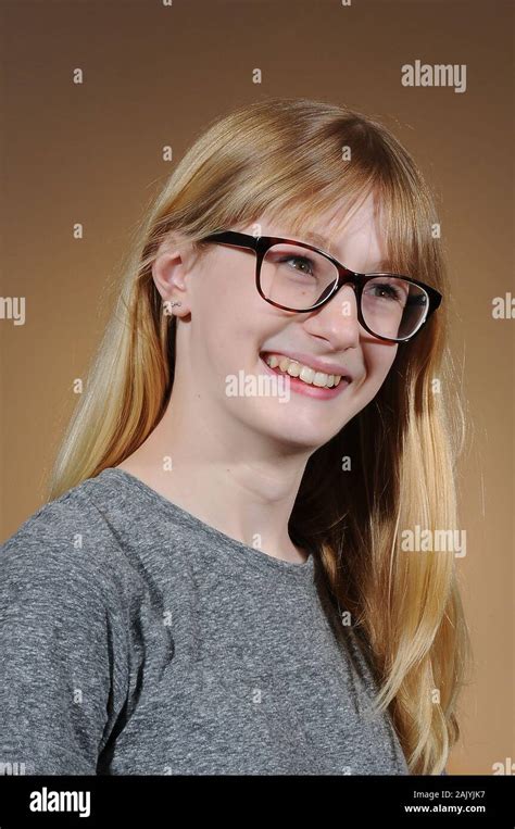 Pretty Blonde Teenage Girl Wearing Black Framed Glasses And A Grey T Shirt Isolated On A