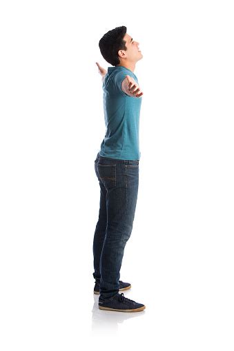 Side View Of Young Man Standing With Arms Outstretched Stock Photo