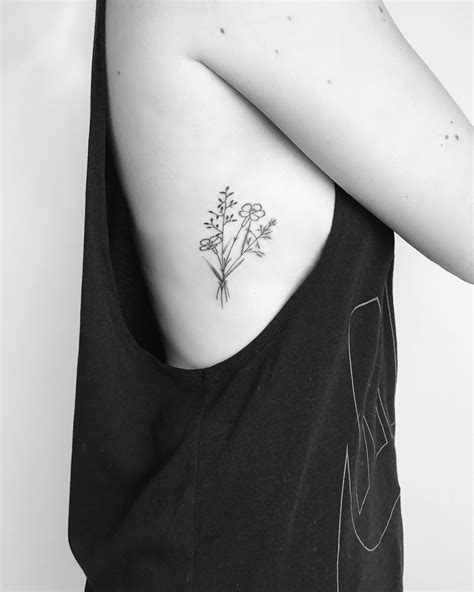 Small minimalist wildflower tattoo with fine black lines and detailing
